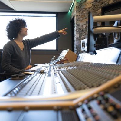 young-curly-hair-caucasian-woman-working-in-a-musi-2023-11-27-05-16-33-utc (Small)